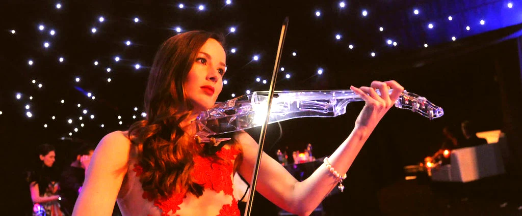 Electric string quartet with light-up violin performing under starfield lighting