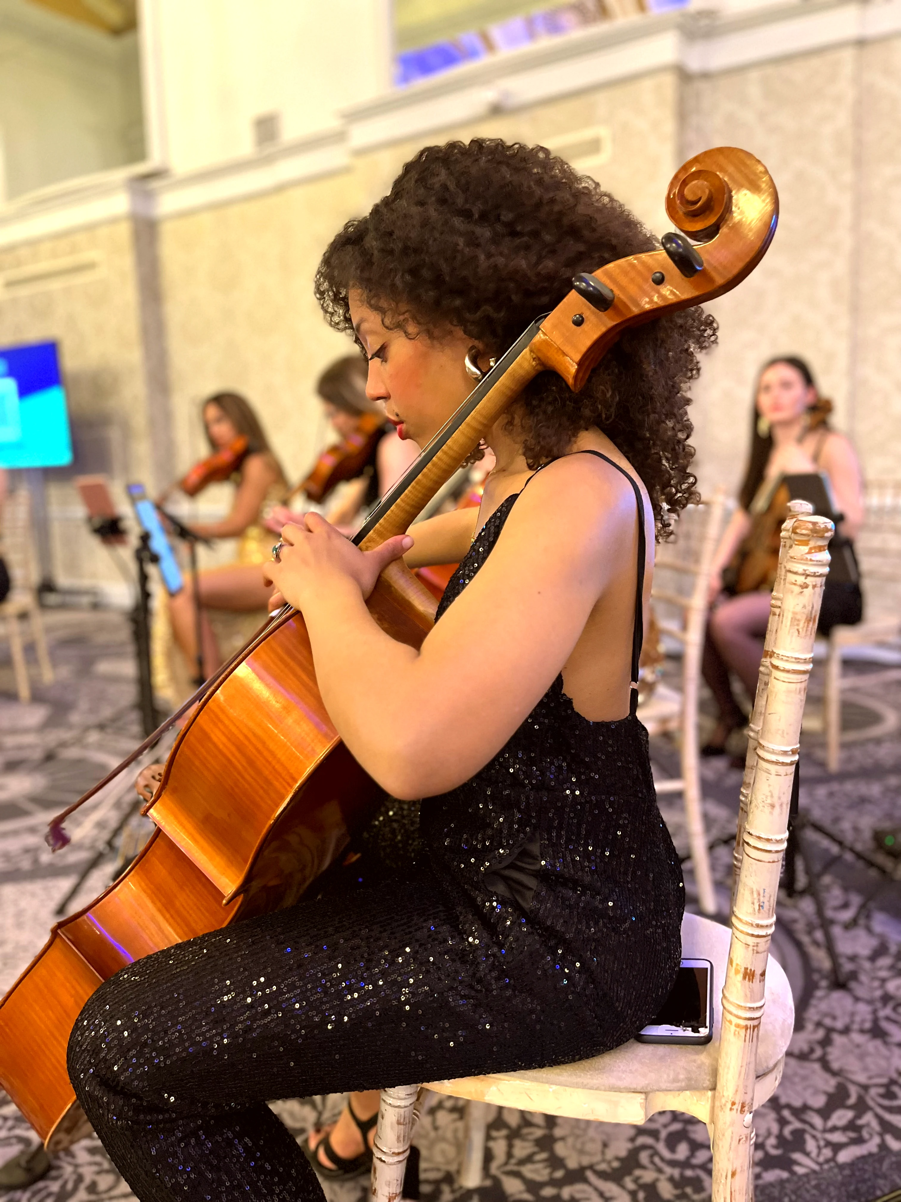 Cellist in sequin gown performing at a London corporate event