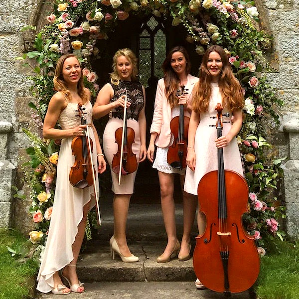 Secret Strings string quartet at a church wedding with floral arch