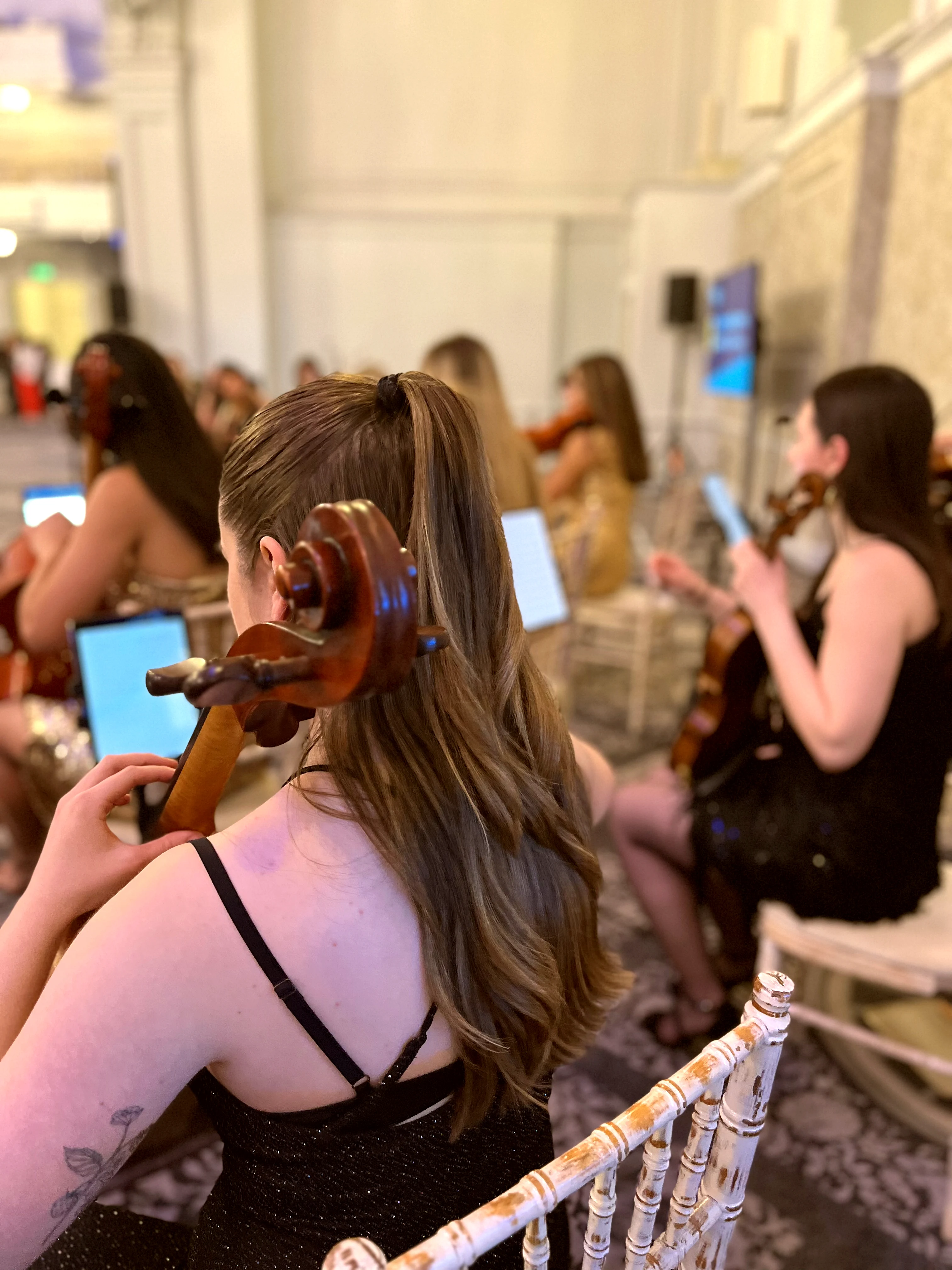 Cello and violin players from behind in an elegant London event space