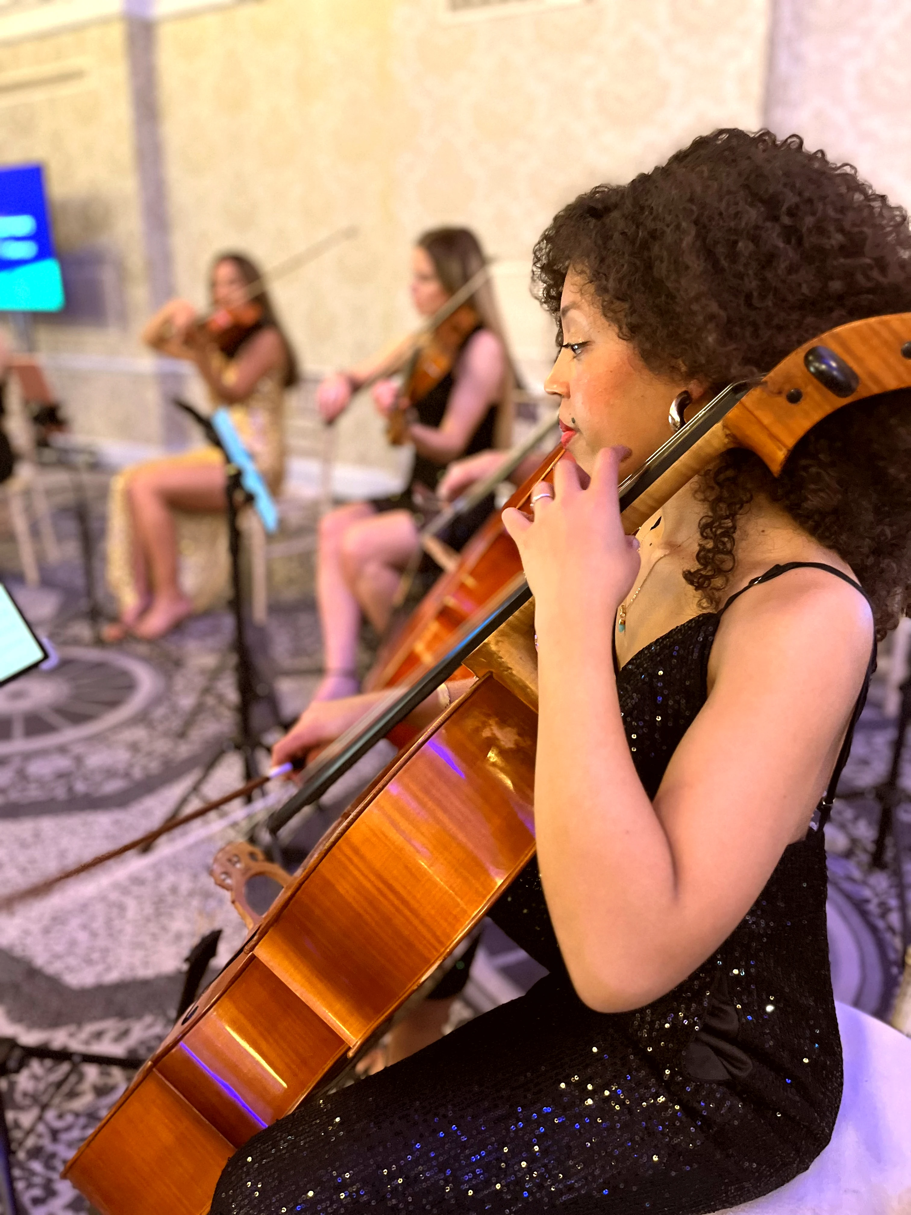 Cellist performing at a London event with string orchestra