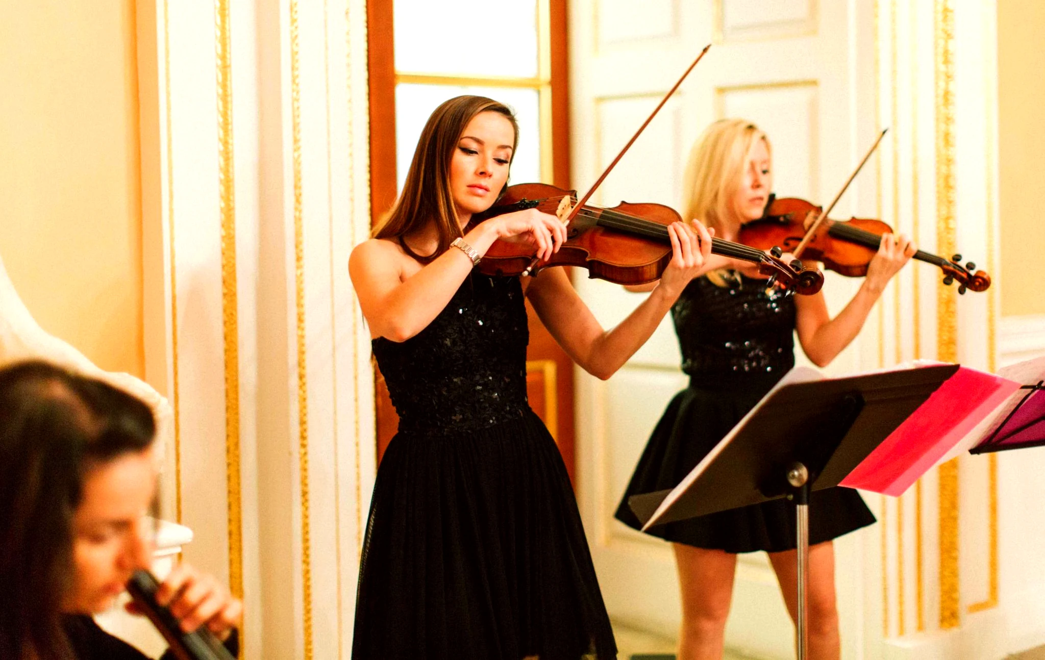 Secret Strings string quartet performing in an elegant white and gold ballroom